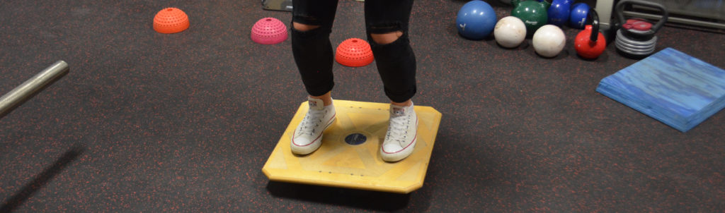 Physiotherapy patient balancing on exercise board