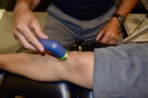 Physiotherapist providing ultrasound treatment to patient's knee