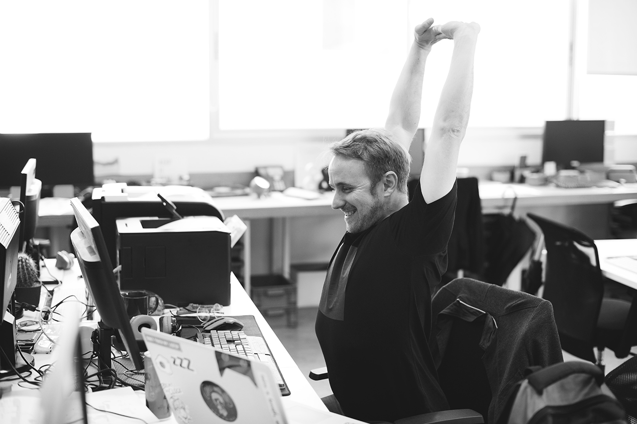 Person at desk stretching arms
